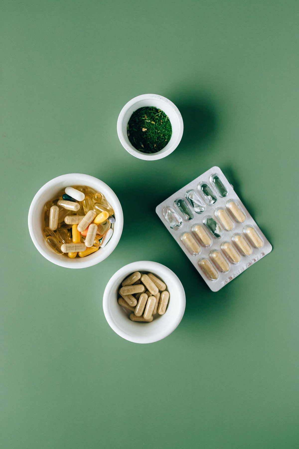 Suplementos en cápsulas sobre fondo verde